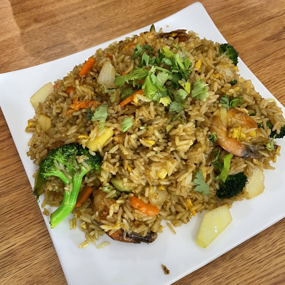 Mercy Thai Restaurant's fried rice with shrimp, broccoli, carrots, and cilantro on a white plate.